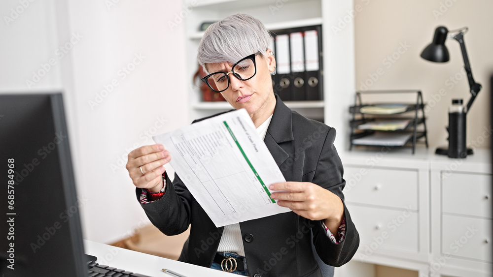 Young woman business worker using computer reading document at office Young woman business worker using computer reading document at office