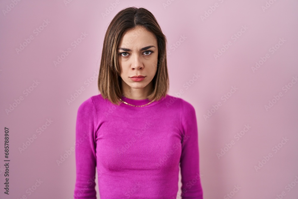 Hispanic woman standing over pink background skeptic and nervous, frowning upset because of problem. negative person.