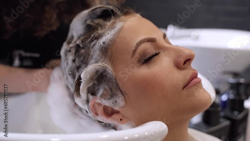 Woman with short hair washing her hair in hair salon photo