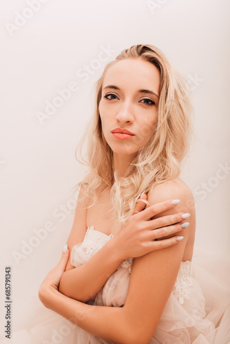 Beautiful woman in white dress sitting at table. Reverie, anticipation