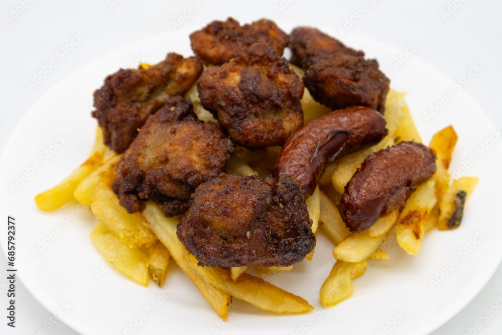 Japanese Karaage Fried Chicken with Fries and Sausage on a White Plate