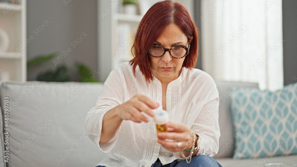 Middle age woman reading pills bottle information at home Middle age woman reading pills bottle information at home