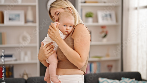 Mother and daughter hugging each other standing at home