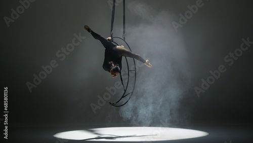 Rhythmic gymnastics girl performs the scum on one arm in the air on a metal rotating structure moon. photo