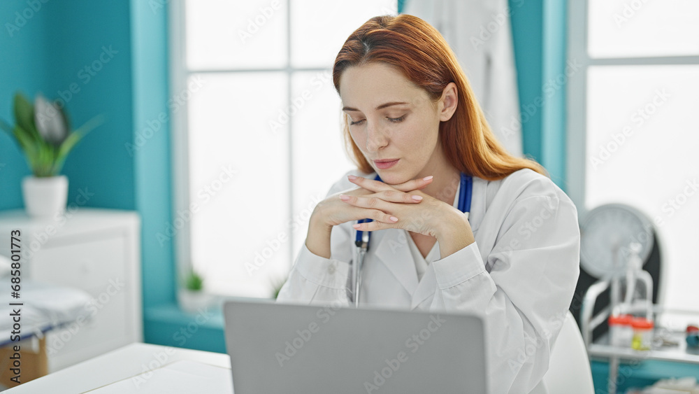 Young redhead woman doctor using laptop at clinic Young redhead woman doctor using laptop at clinic
