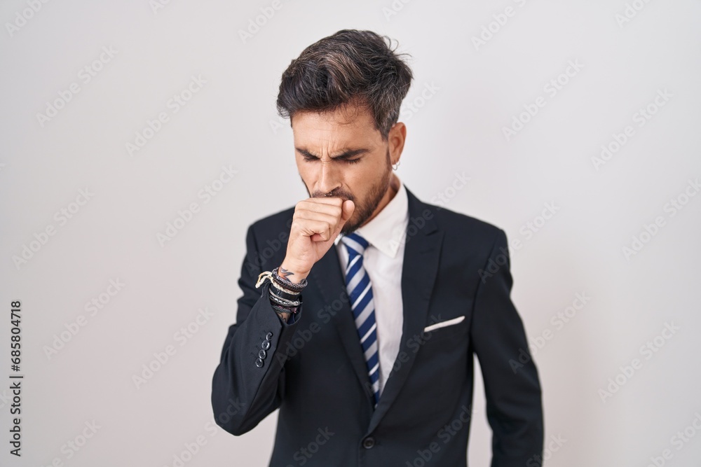 Young hispanic man with tattoos wearing business suit and tie feeling unwell and coughing as symptom for cold or bronchitis. health care concept. Young hispanic man with tattoos wearing business suit and tie feeling unwell and coughing as symptom for cold or bronchitis. health care concept.