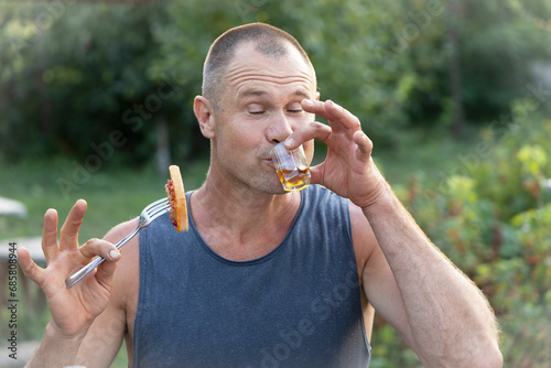 A man drinks alcohol with pleasure.