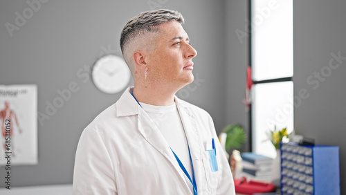 Young caucasian man doctor standing with serious expression at the clinic