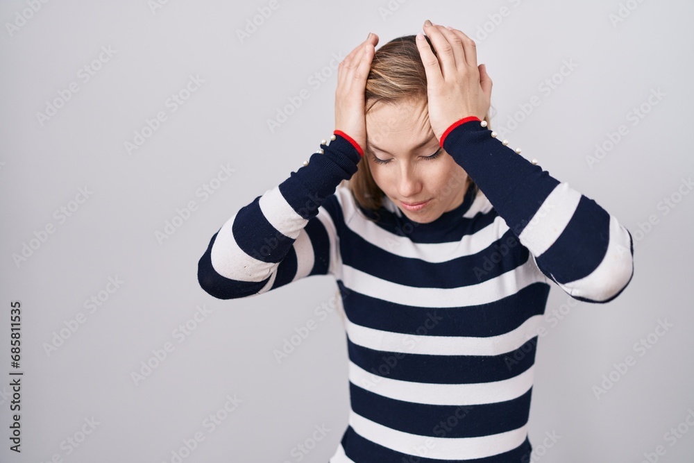Young caucasian woman wearing casual navy sweater suffering from headache desperate and stressed because pain and migraine. hands on head. Young caucasian woman wearing casual navy sweater suffering from headache desperate and stressed because pain and migraine. hands on head.