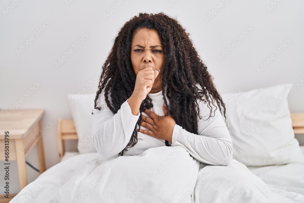 African american woman sitting on bed coughing at bedroom