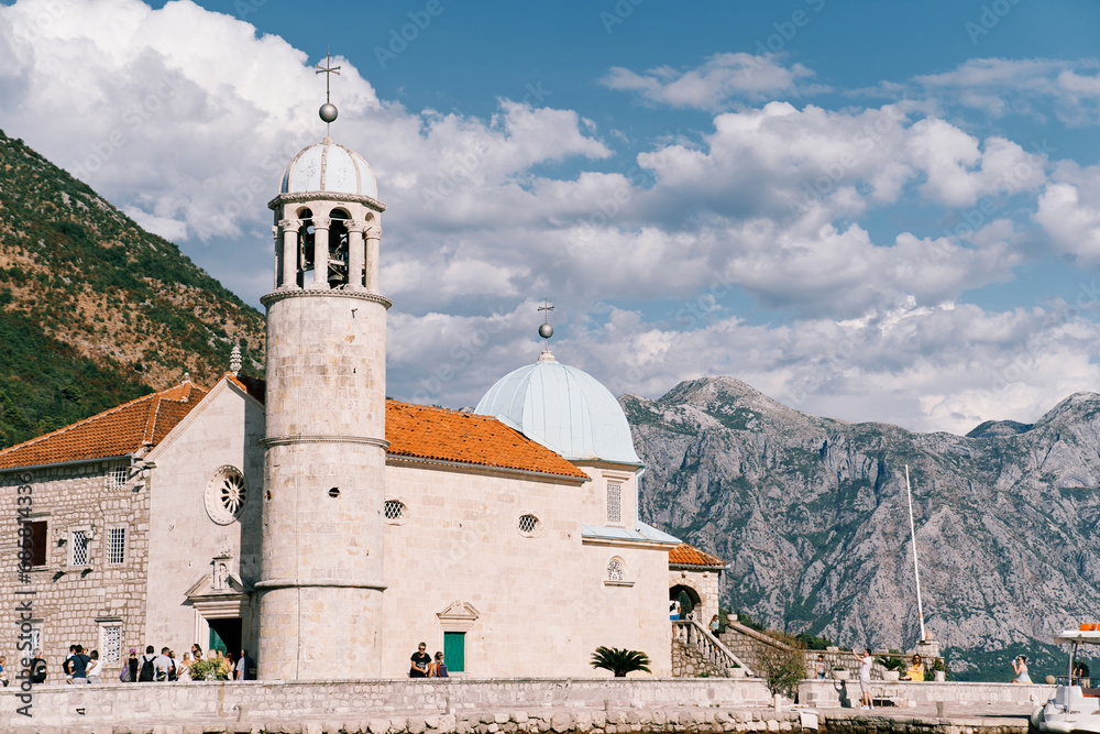 Tourists stand at the Church of Our Lady of the Rocks on an island in the Bay of Kotor. Montenegro