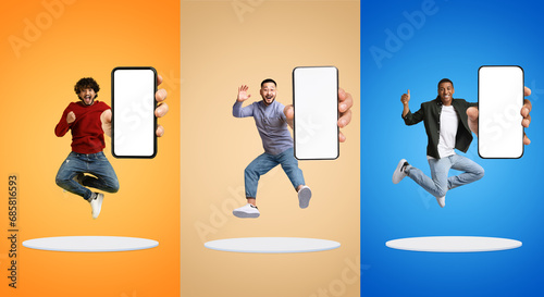 Glad excited millennial diverse men show phone with empty screen, jump at platform, have fun