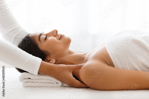 Joyful woman getting relaxing body shoulders massage at wellness center