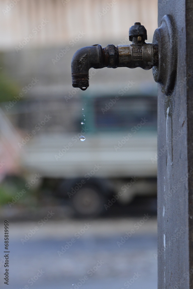 Water dripping from faucet of ancient iron fountain Water dripping from faucet of ancient iron fountain
