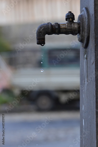 Water dripping from faucet of ancient iron fountain