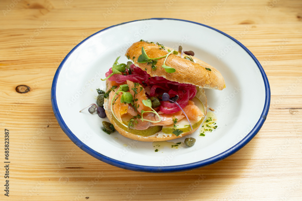 Fototapeta premium Closeup of smoked salmon bagel sandwich on wooden board