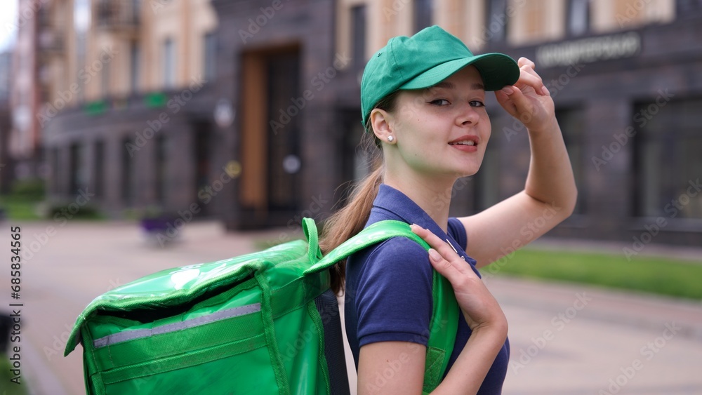 Happy young woman or teenager girl courier in green uniform with big ...