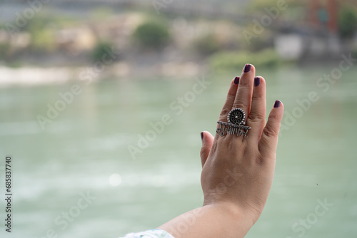 Hands of indian woman with purple nail polish and ring saying musafir meaning traveller in Hindi showing the trend of travelling photo