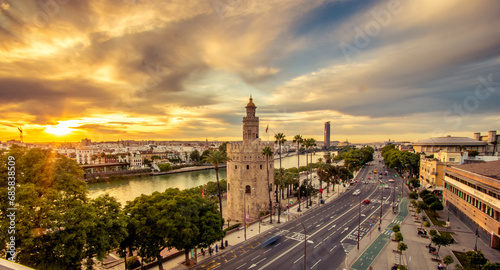 Vista dramática de la Torre del Oro y Río Guadalquivir de Sevilla al atardecer con nubes en el cielo