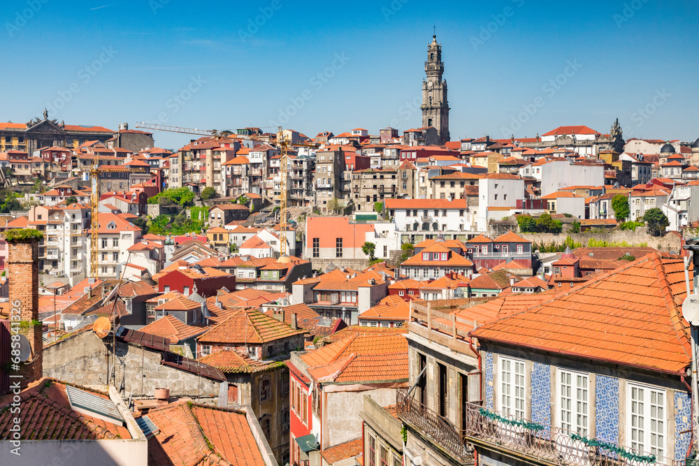 View across the tiled roofs of Porto, Portugal, on a fine spring day. The skyline is dominated by the tower of the Igreja dos Clérigos, the Church of the Clerics.