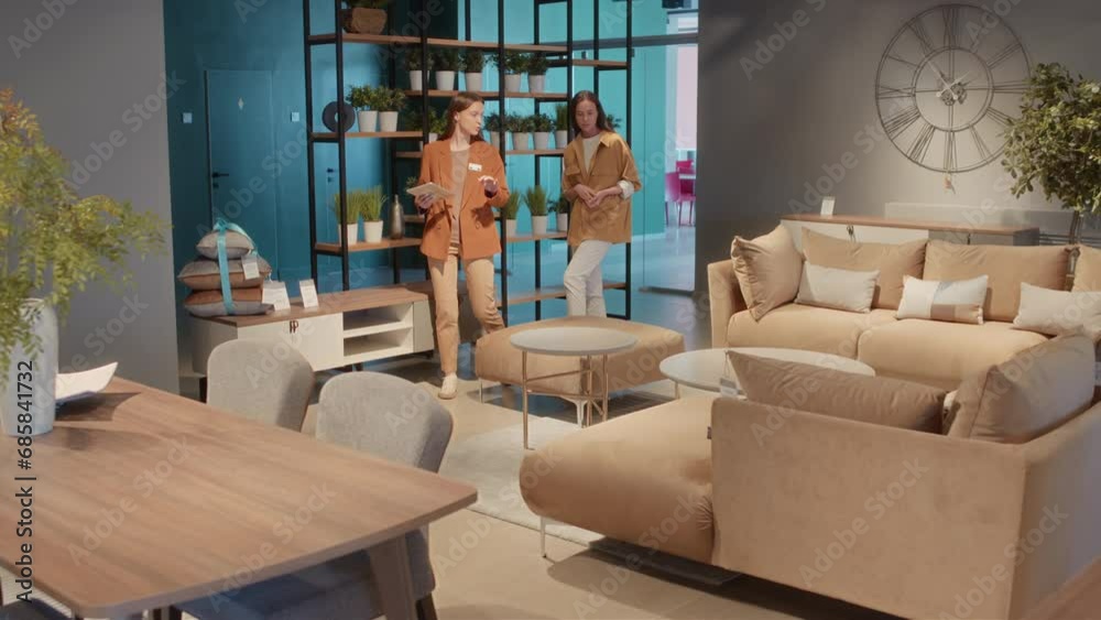 Customer service supervisor in furniture retail showing her client mock-up of living room made in beige tones