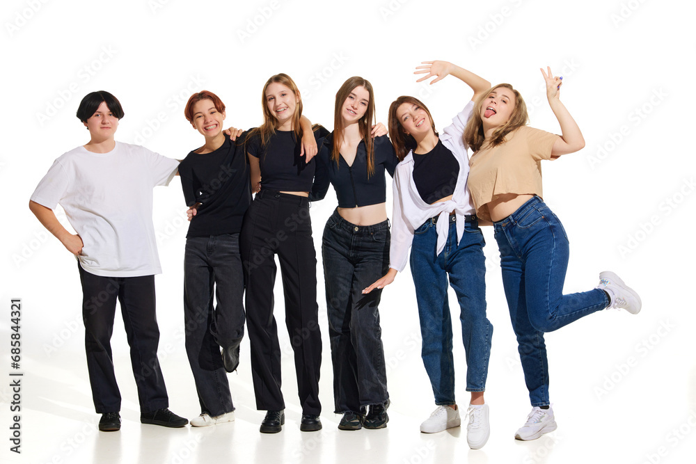 Group of young attractive beautiful people, women standing against on white studio background. Concept of beauty, youth, emotions, fashion, style, modelling. Copy space for ad, text.