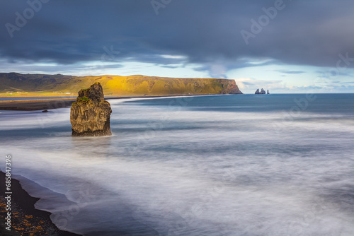 Long exposure image of the south-coast of Iceland with cliffs, sea-stacks and Reynisfjara beach in the vicinity of the village of Vik photo