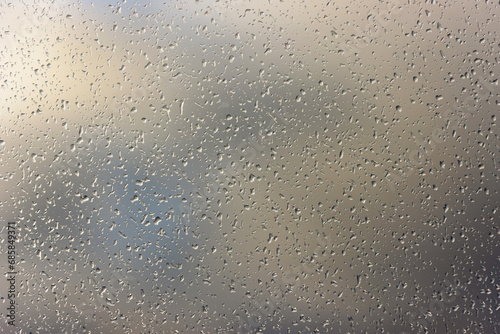 The window glass is covered with many small raindrops