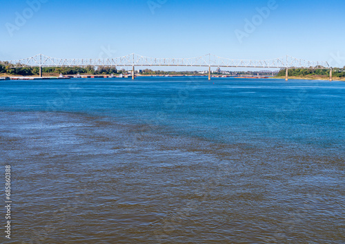 Принти на полотні Barges wait at the confluence of the blue Ohio river and brown Mississippi river