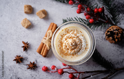 Eggnog with cinnamon decorated with whipped cream in a glass