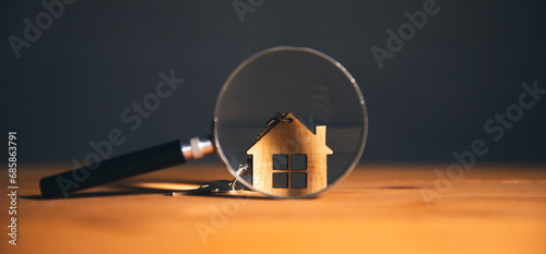 Wooden house and magnifying glass