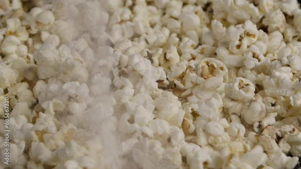 Sprinkling salt on popcorn. Slow Motion. Macro shot. Sprinkling salt on popcorn. Slow Motion. Macro shot.