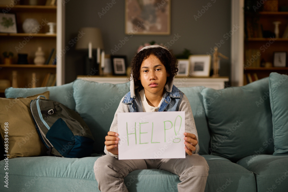 Teenage boy holding paper card with word Help Teenage boy holding paper card with word Help