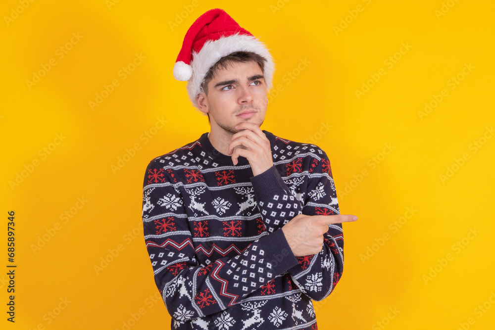 isolated young man or teenager with santa claus hat and christmas sweater isolated young man or teenager with santa claus hat and christmas sweater