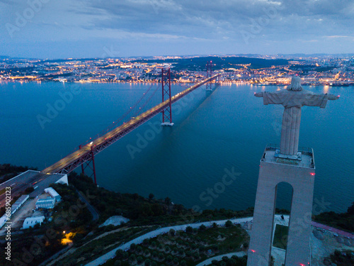 Panoramic landscape of 25th April Bridge, Cristo Rei monument and Lisbon in lights