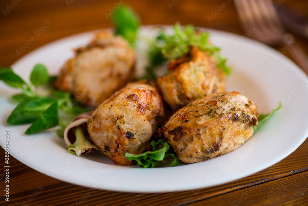 Fried pieces of chicken fillet breaded with spices and herbs in a plate . Fried pieces of chicken fillet breaded with spices and herbs in a plate .