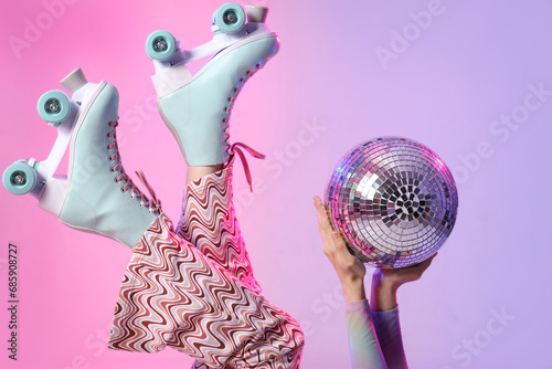 Beautiful young woman in roller skates with disco ball on color background, closeup photo