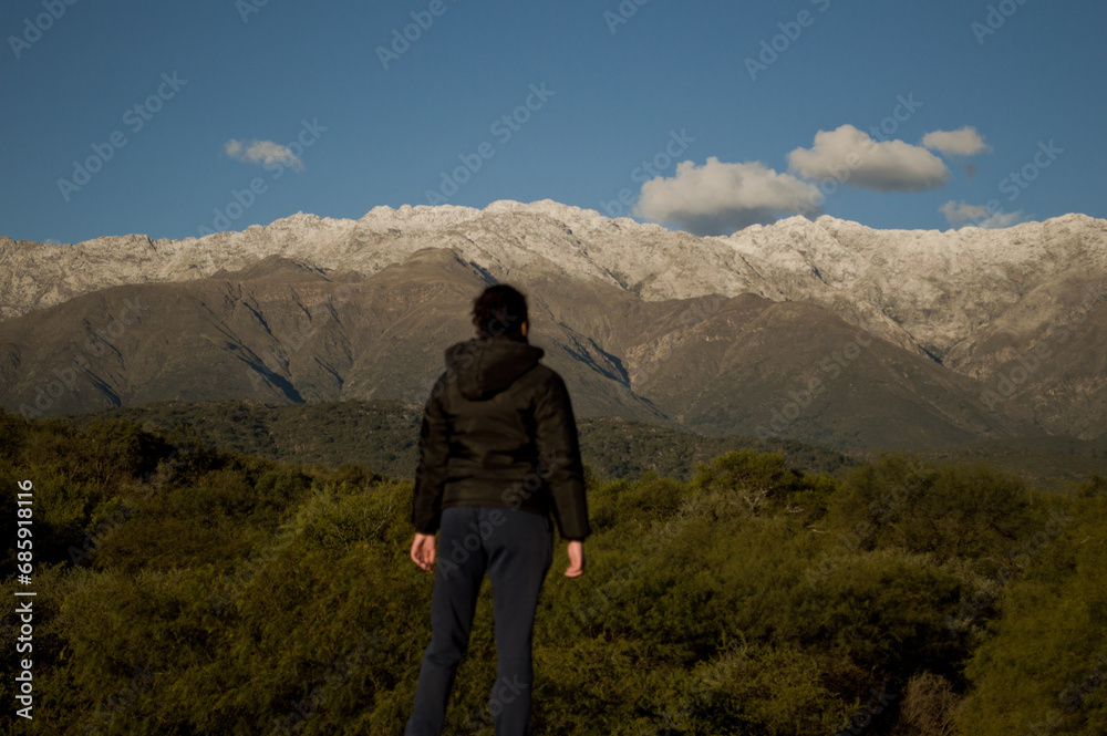 Landscape of a girl looking towards snowy mountains
