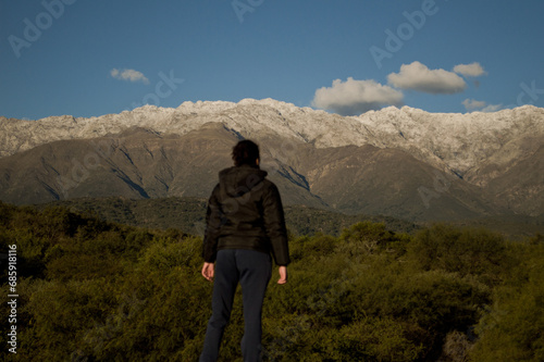 Landscape of a girl looking towards snowy mountains photo