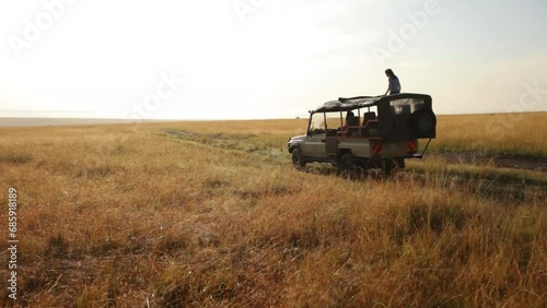 Silhouette of woman standing in moving safari vehicle photo