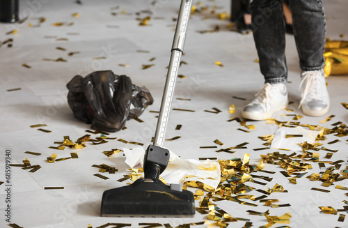 Female janitor cleaning floor in office after New Year party, closeup