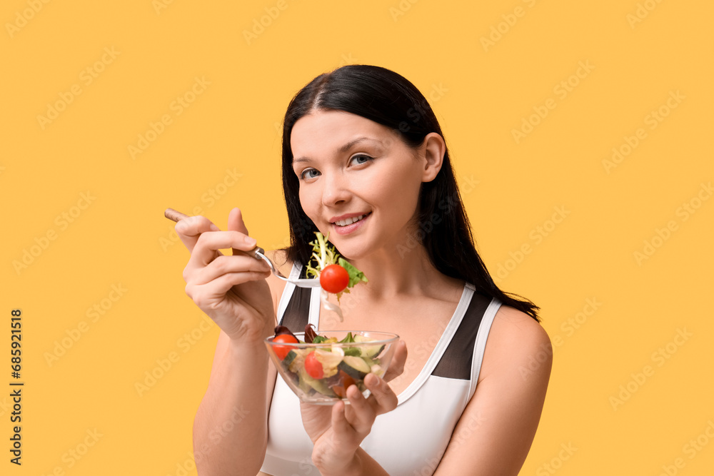 Beautiful young happy woman with bowl of fresh vegetable salad on yellow background. Weight loss concept Beautiful young happy woman with bowl of fresh vegetable salad on yellow background. Weight loss concept