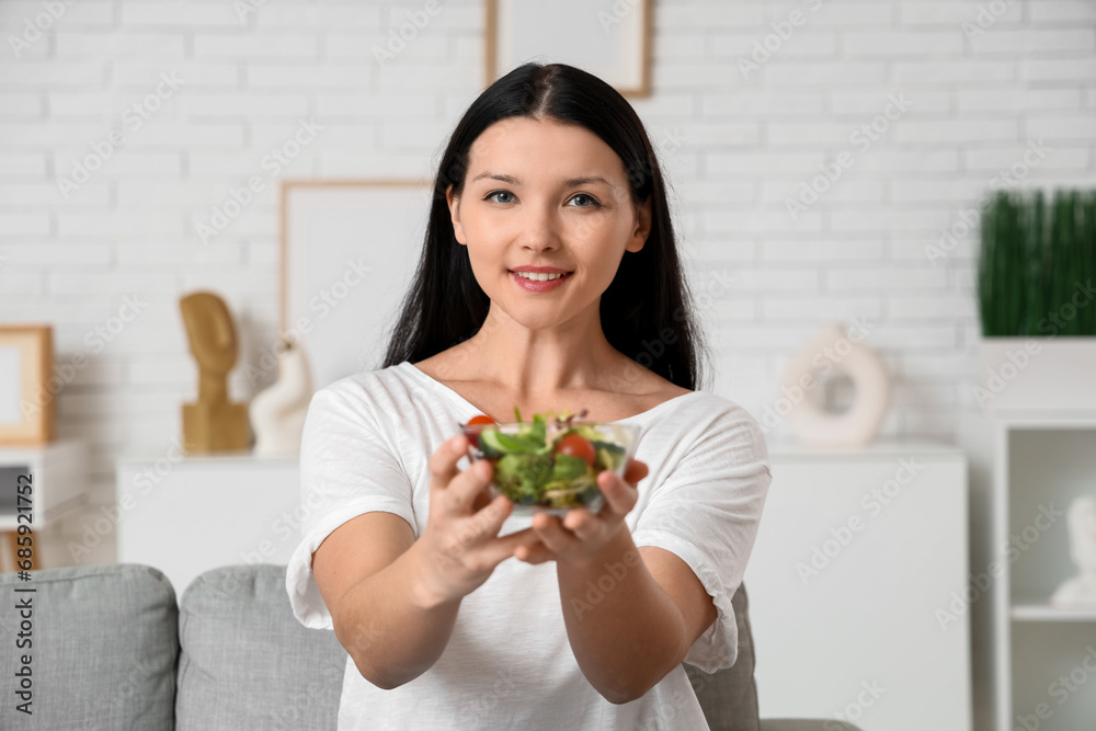 Beautiful young woman with bowl of fresh vegetable salad at home. Weight loss concept Beautiful young woman with bowl of fresh vegetable salad at home. Weight loss concept