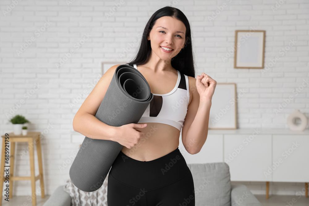 Beautiful young sporty woman with yoga mat at home. Weight loss concept Beautiful young sporty woman with yoga mat at home. Weight loss concept
