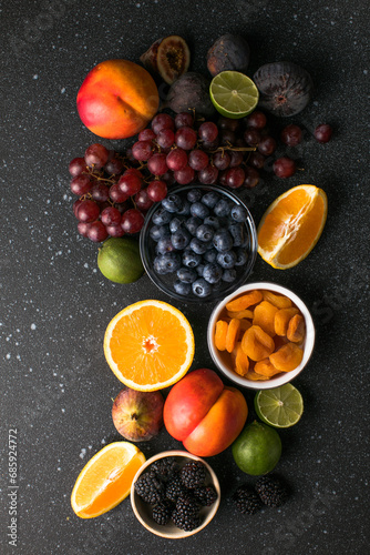 Assortment of fresh exotic fruits and berries on concrete table, flat lay