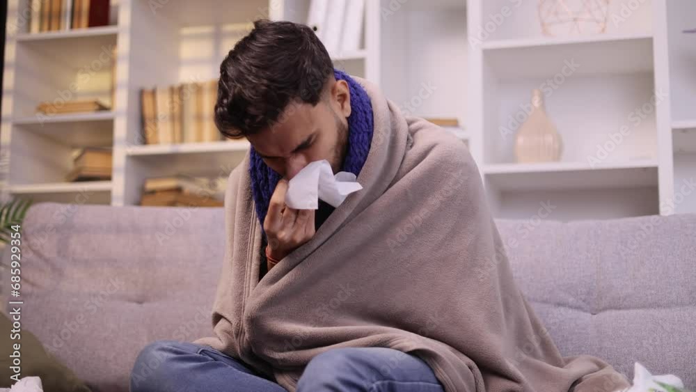 Sick unhealthy young man on couch with warm scarf coughing sneezing and having severe headache temperature indoors Sad tired guy getting flu virus symptom at cold season at home Sick unhealthy young man on couch with warm scarf coughing sneezing and having severe headache temperature indoors Sad tired guy getting flu virus symptom at cold season at home