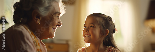 Image of a grandmother and granddaughter happily talking in their living room. photo