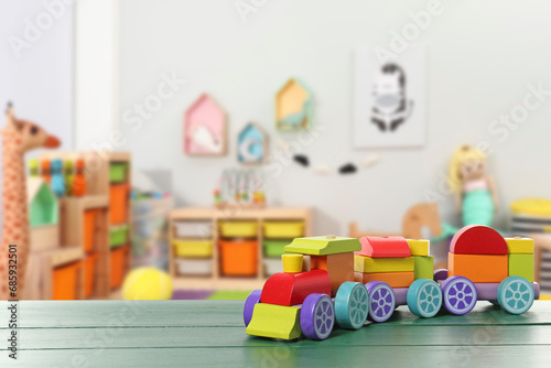 Bright toy train on green wooden table in kindergarten. Space for text © New Africa