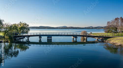 A pedestrian bridge in a city park by the lake