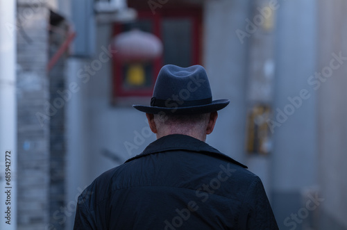 Rear view of adult man in hat on street. Beijing, China